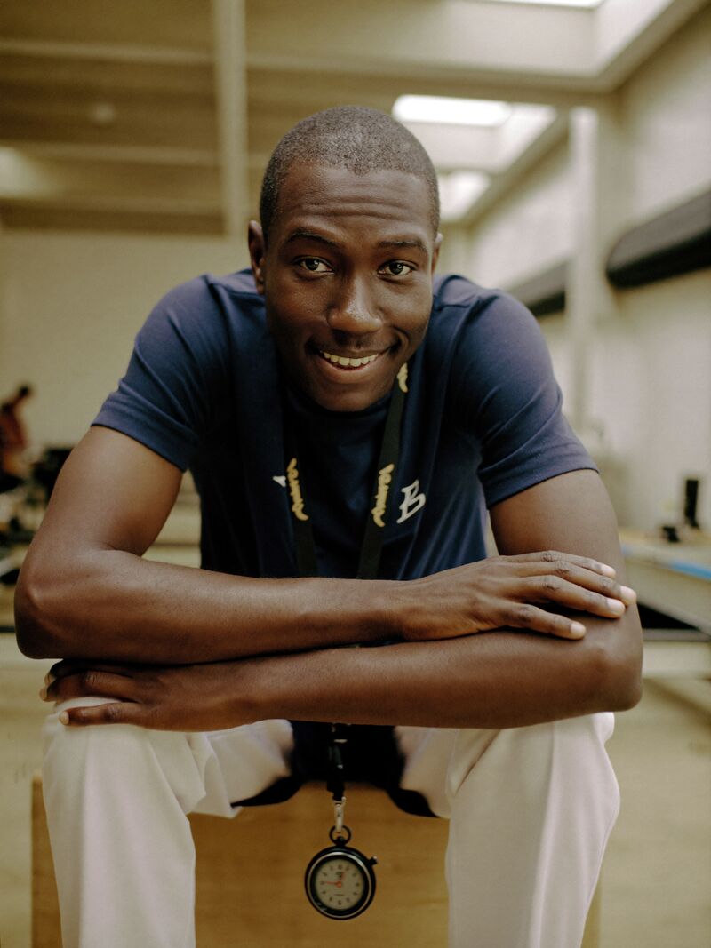 Jess Adeyemi, conditioning coach, sitting on a plyo box mid-conversation