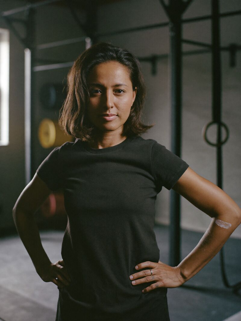 Nadia Brandt, head coach, standing on the gym floor with her arms folded